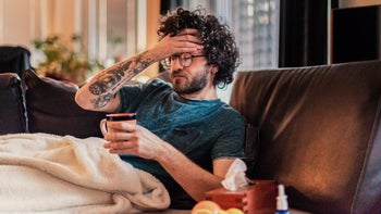 STDs: Genital herpes symptoms: sick-on-couch-drinking-tea-1142476231
