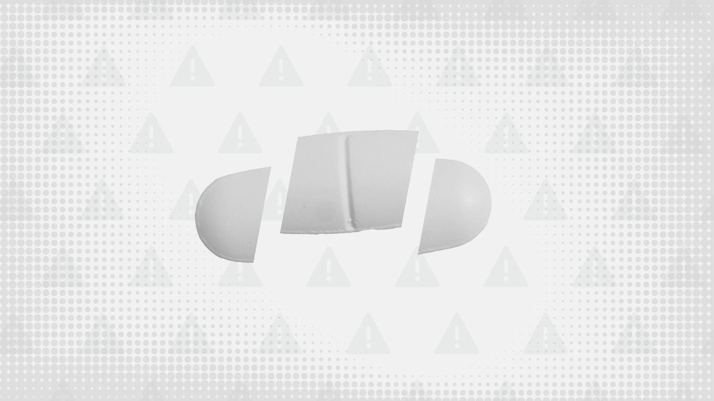 Gray background with texture and warning sign pattern. In the center is an oblong white pill cut into thirds.
