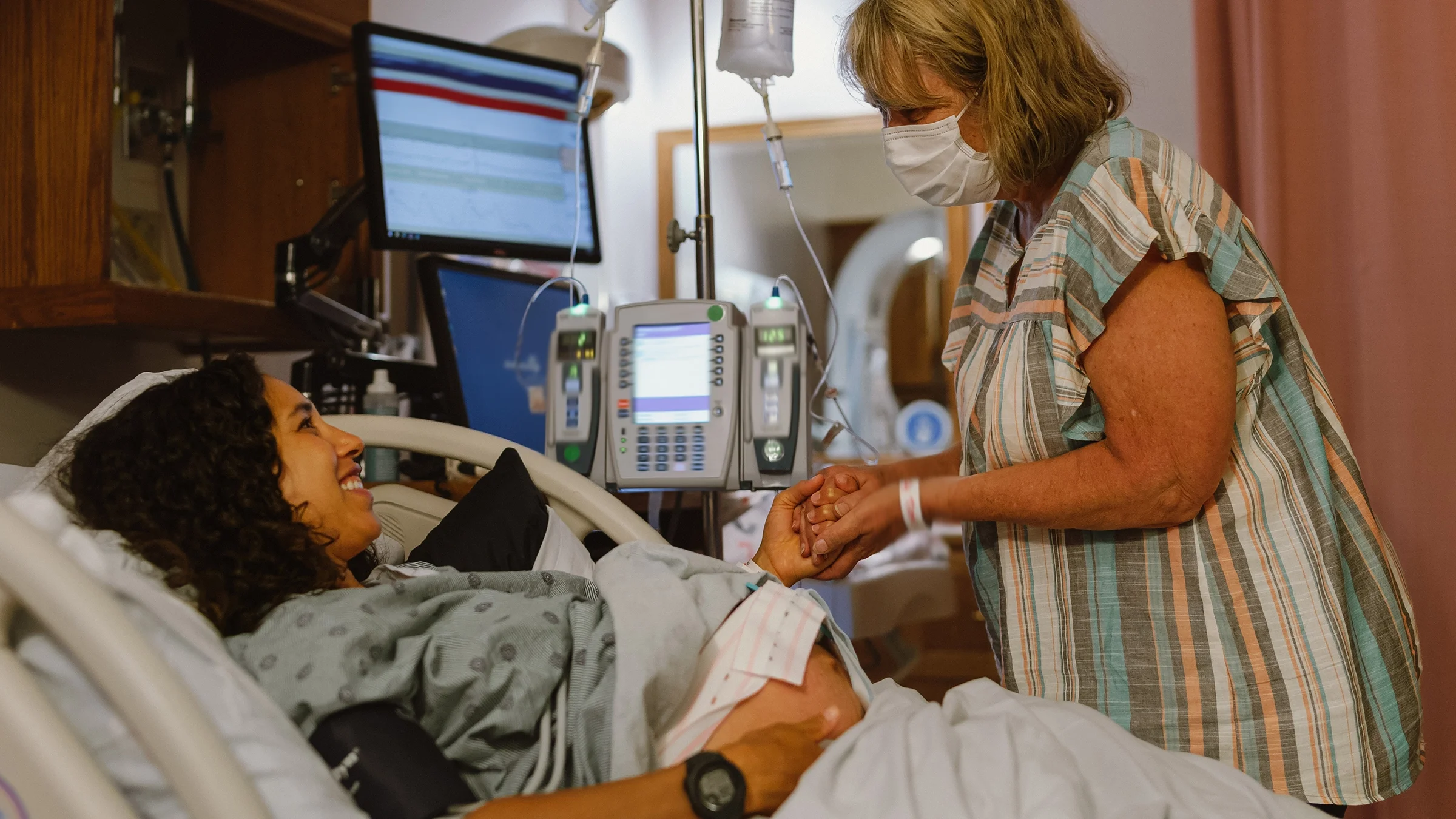 Doula in delivery room with pregnant woman.