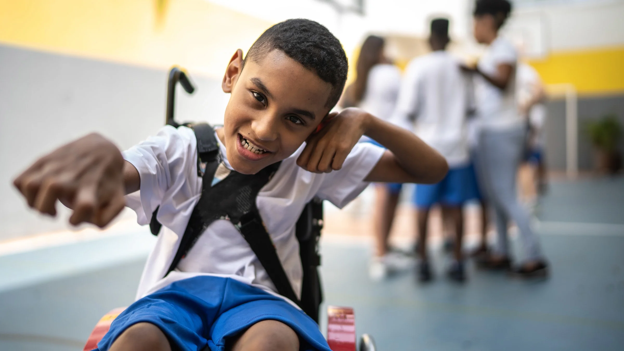 A young student in a wheelchair at a sports court.