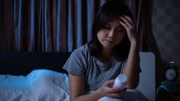 Dayvigo: woman with insomnia holding medication 1336006584