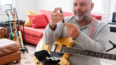 A guitarist checking their blood sugar.
Fertnig/E+ via Getty Images 