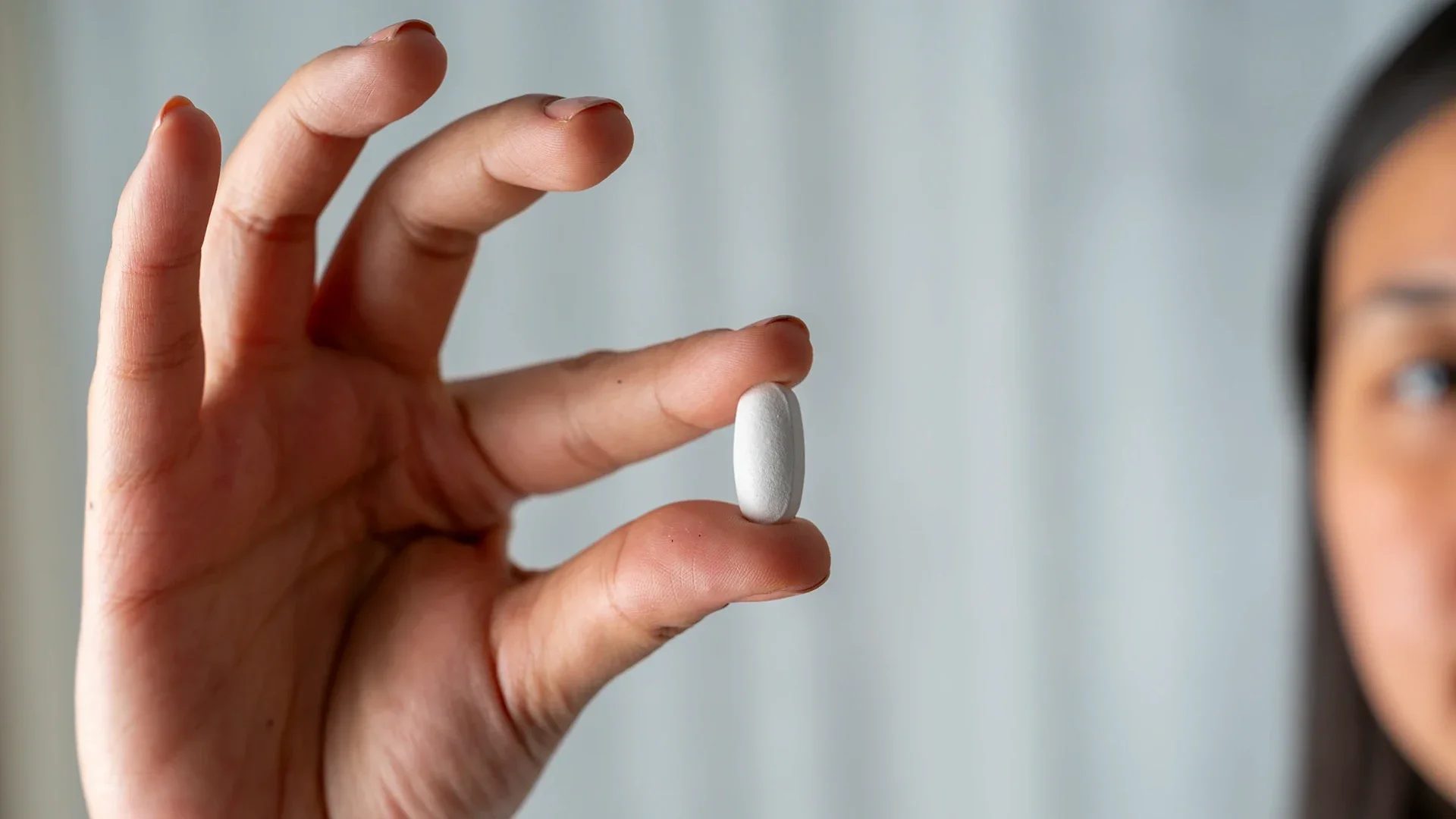 Weight Loss: closeup hand holding a pill 2230071835
