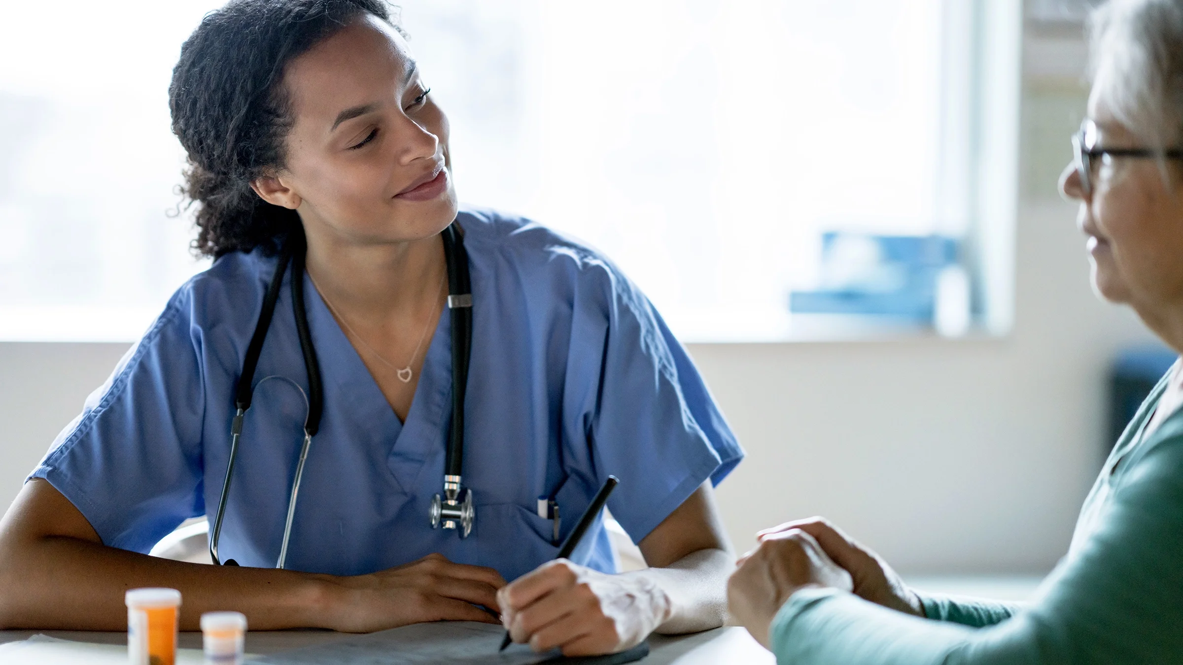 A medical professional is speaking to an older patient.