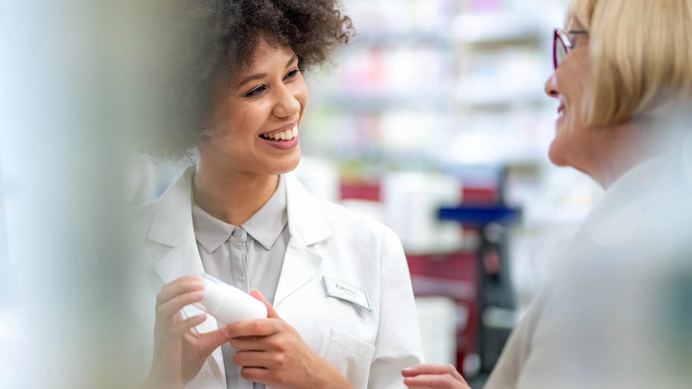 A pharmacist is talking with an older female customer.