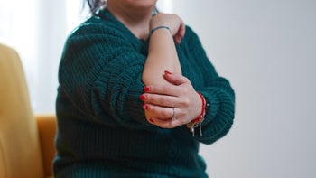 Osteoarthritis: closeup woman with elbow pain 1937556851