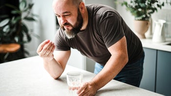 Abilify: man taking medication with water 1792738050
