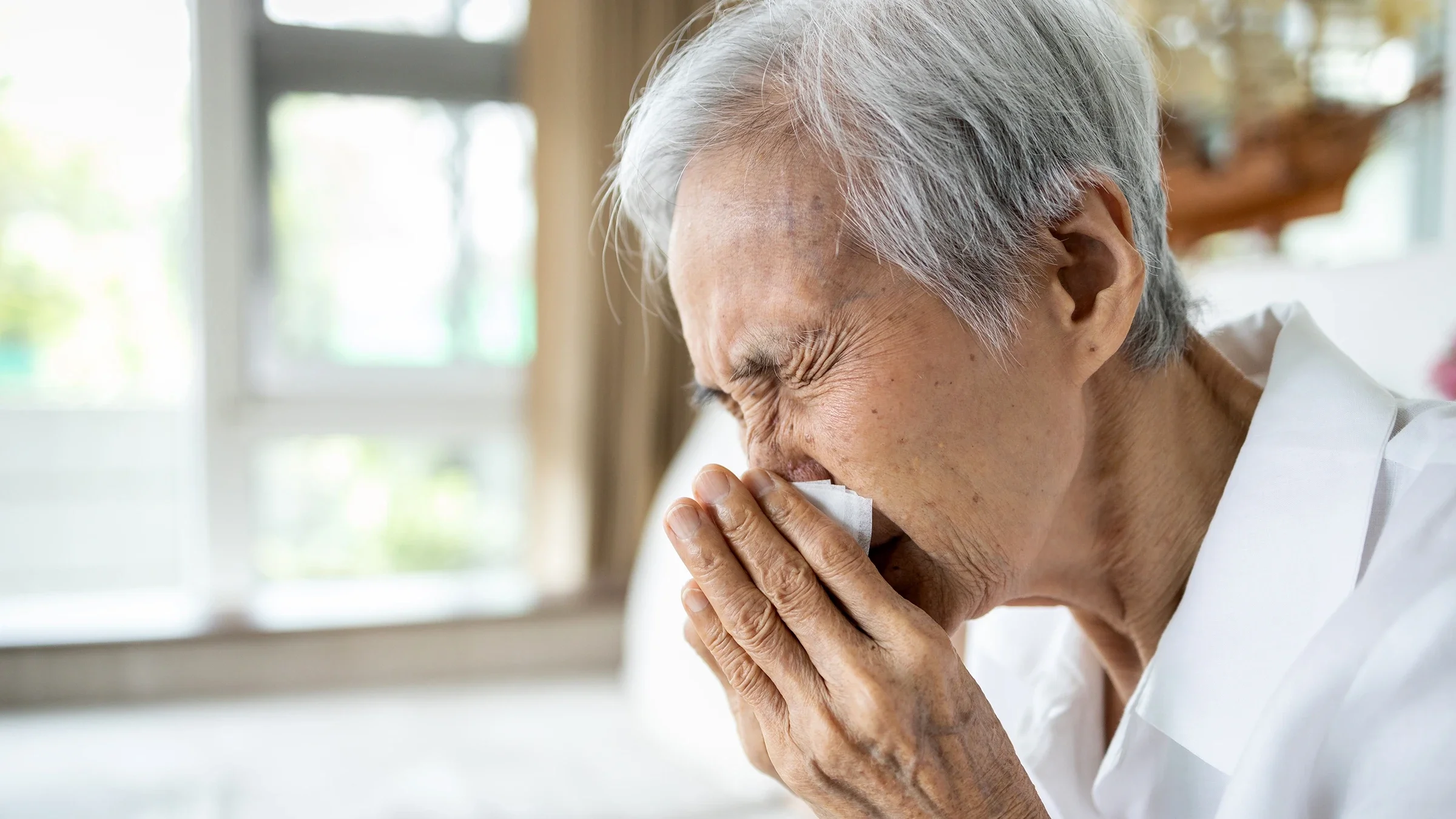 Senior woman blowing her nose