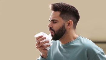 Allergies: Mucinex: man sneezing plain background-1310223150