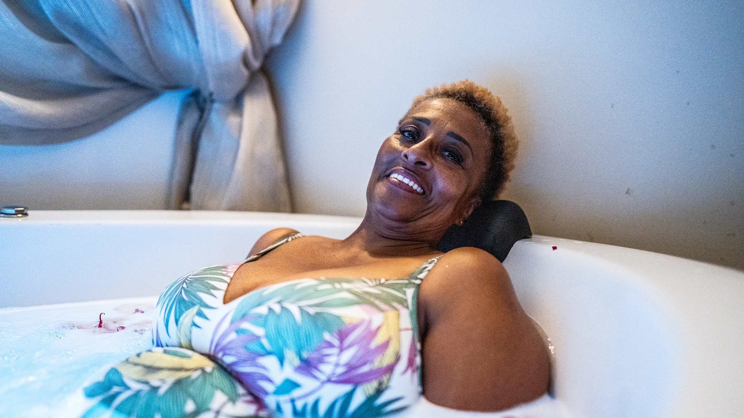 A portrait of a woman soaking in a bathtub.
