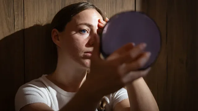 woman looking in the mirror 2228685522