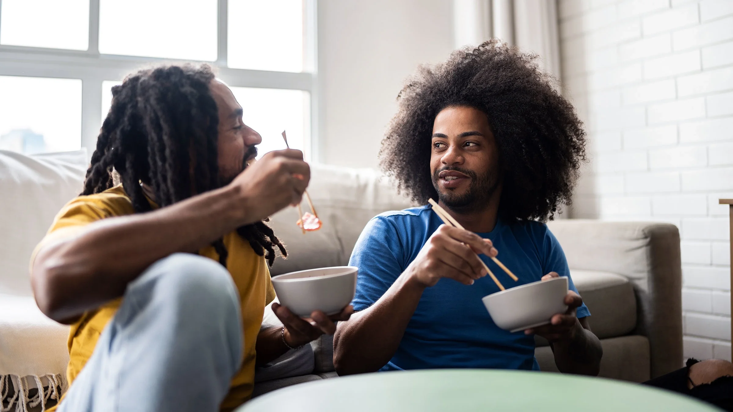 Two men are eating iron-rich foods after donating plasma.