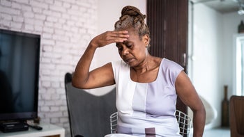 senior woman hand on forehead despair 1298716192