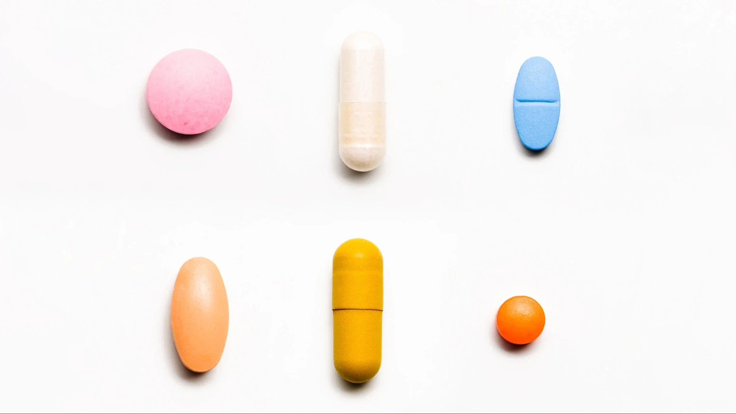 Six colorful pills of various shapes on a white background.
serts/E+ via Getty Images
