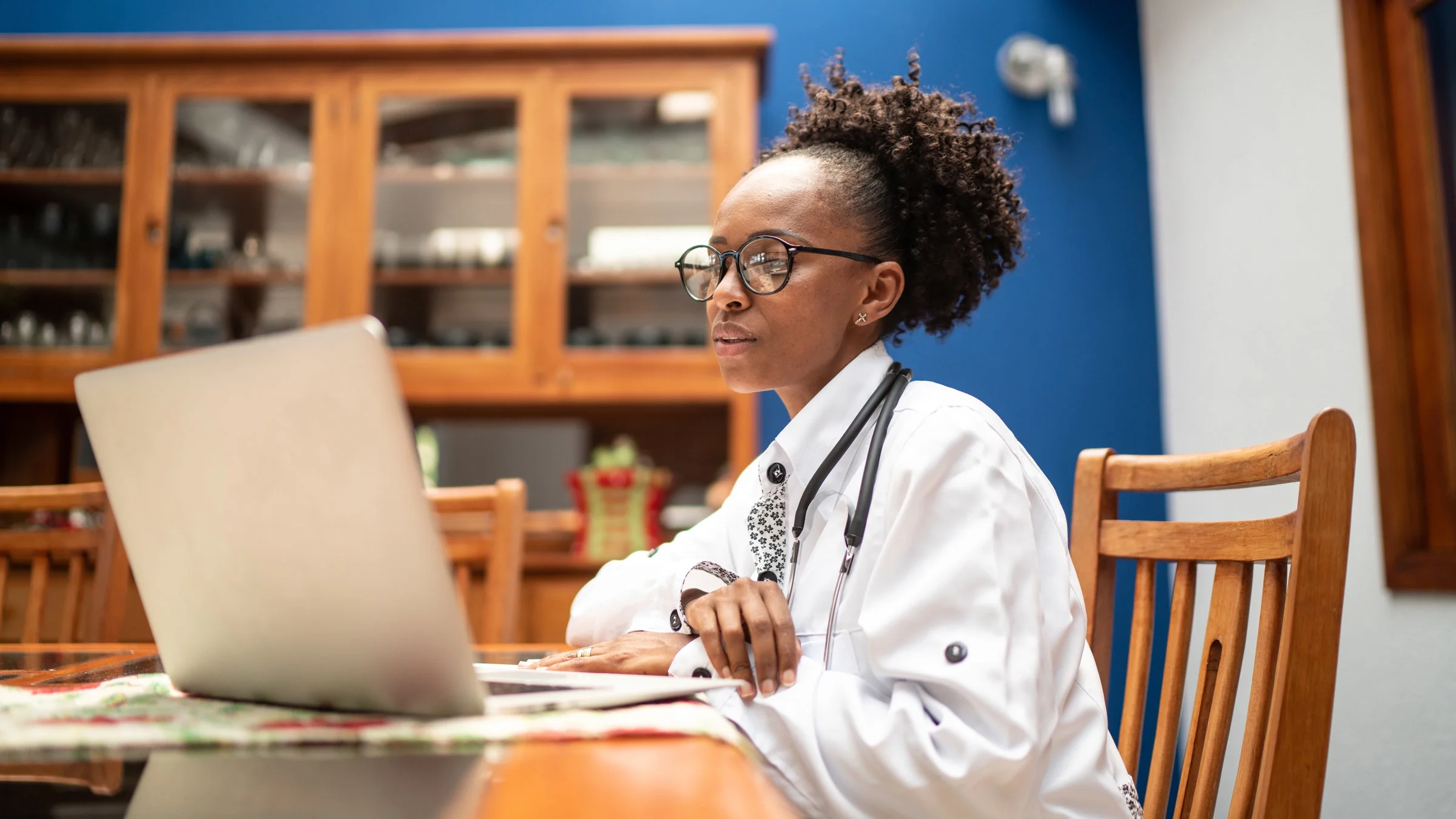 A doctor working from home on their laptop.