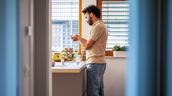 lamotrigine: man taking medication in the kitchen 1461389242