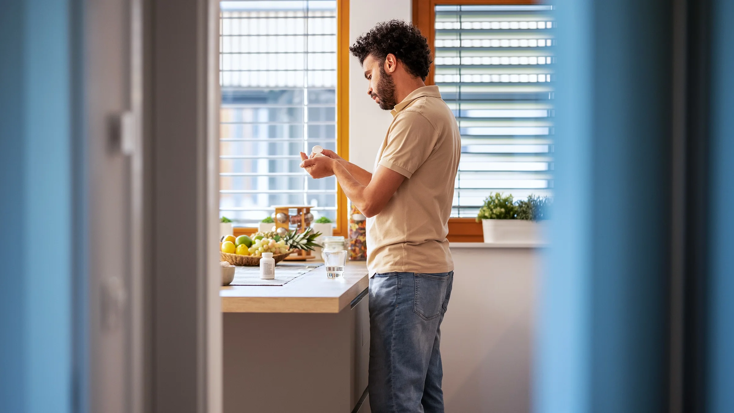 A man prepares to take his medication while in his home.