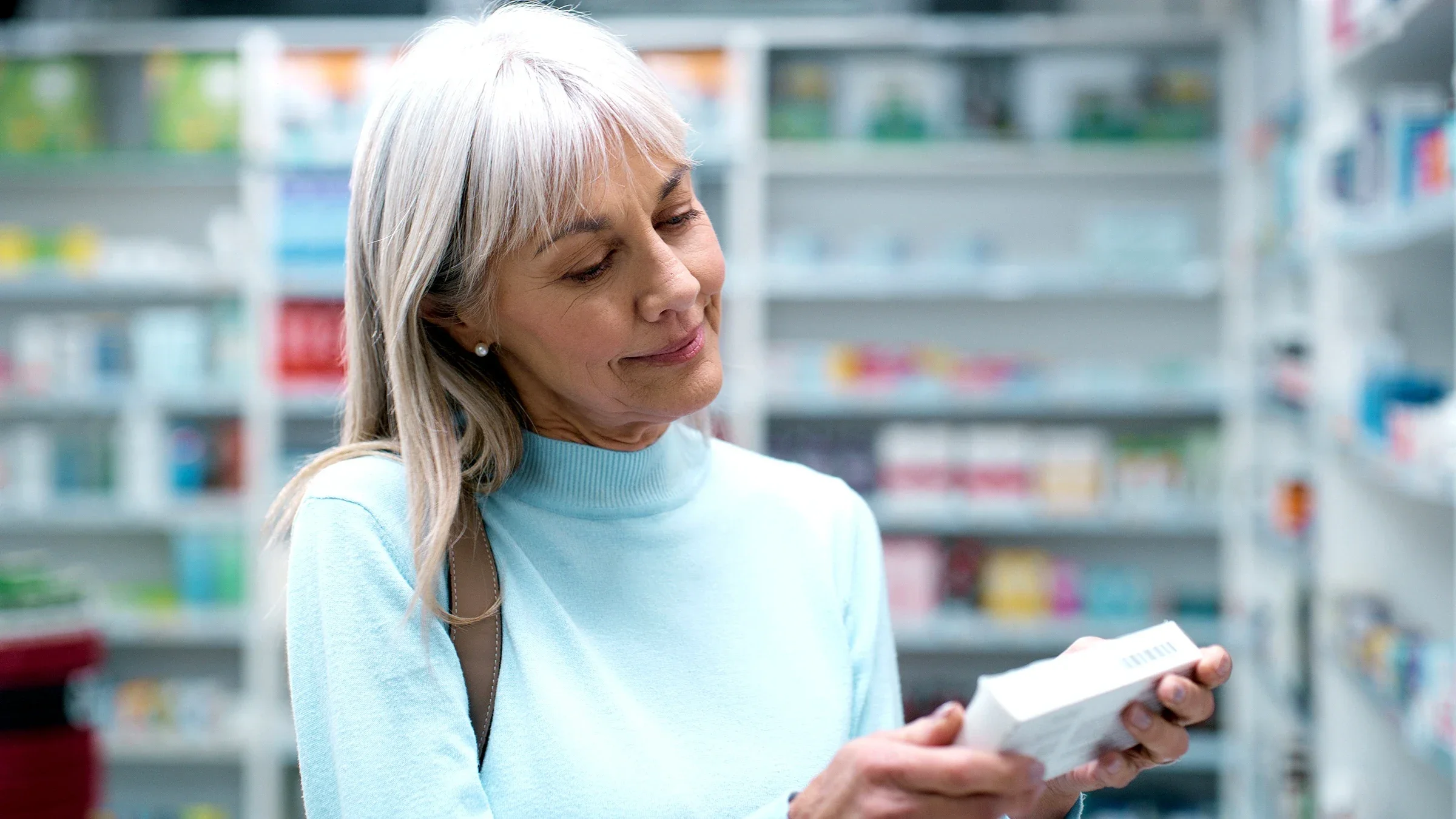 A woman is reading a box of medication at the pharmacy.
Sean Anthony Eddy/E+ via Getty Images