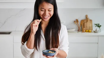 diet-nutrition: woman eating cashews 1471386674