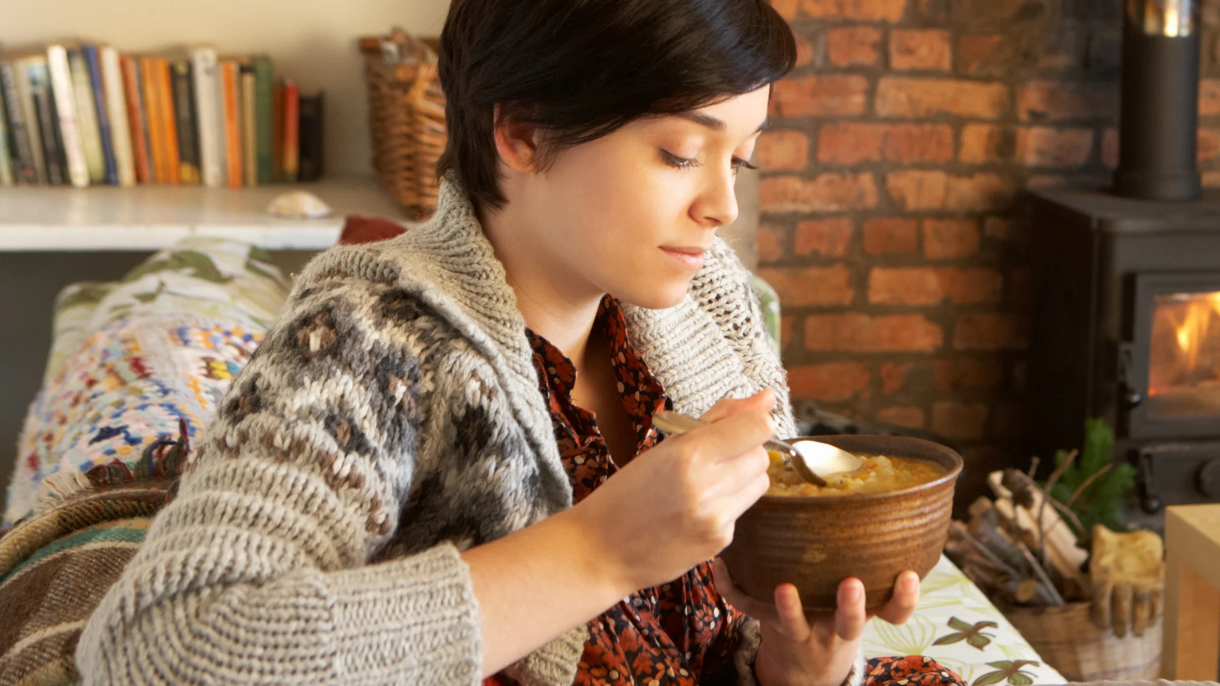 A person is eating soup on their couch.
omgimages/iStock via Getty Images Plus