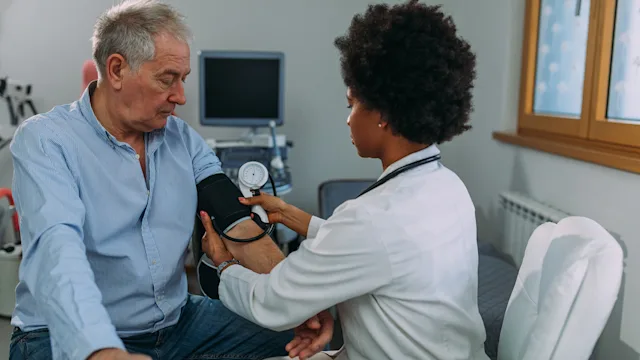 hypertension: doctor measuring patient blood pressure 1309809054