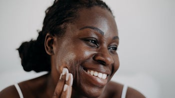 dermatology: woman mosturizing her face 1336484660