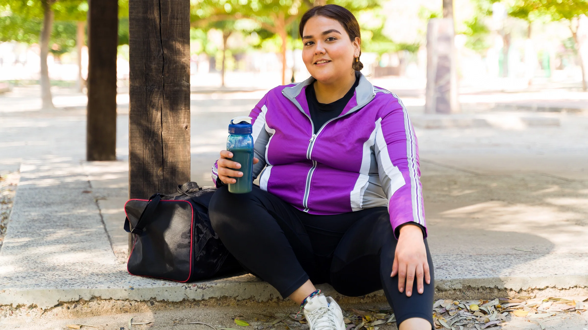 Woman in workout attire drinking a protein shake.