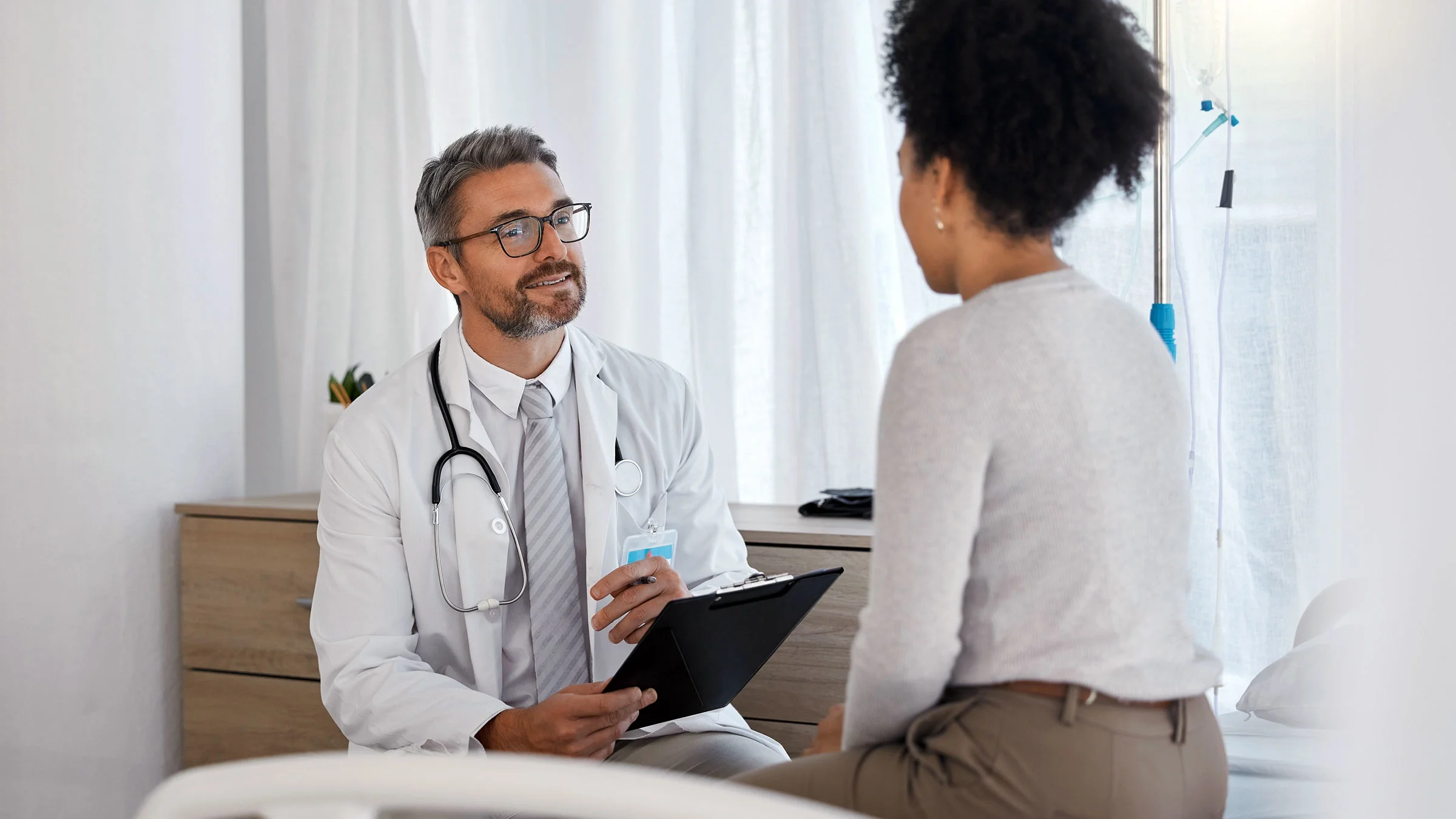 A healthcare professional talks with a person during a health visit. People with pancreatitis or inflammation of the pancreas have several treatment options, such as hydration, medication, and supplements.