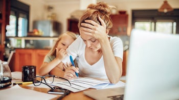 Health: Mental health: stressed woman working from home with child-609798302