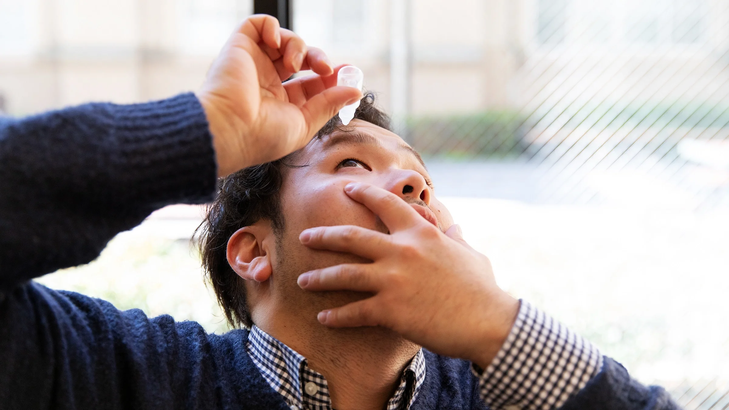 Man using eye drops