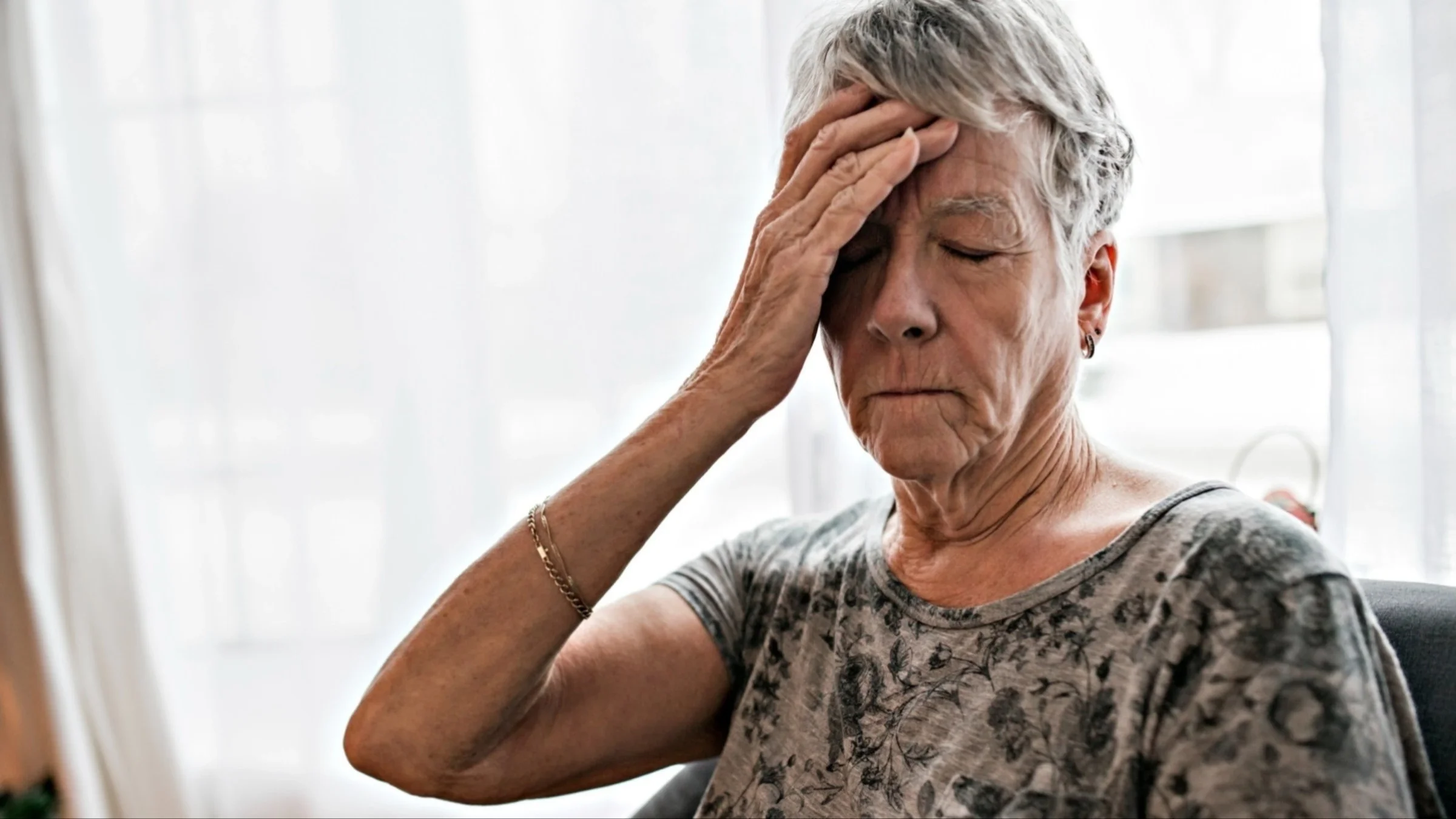 A senior adult experiencing a headache.