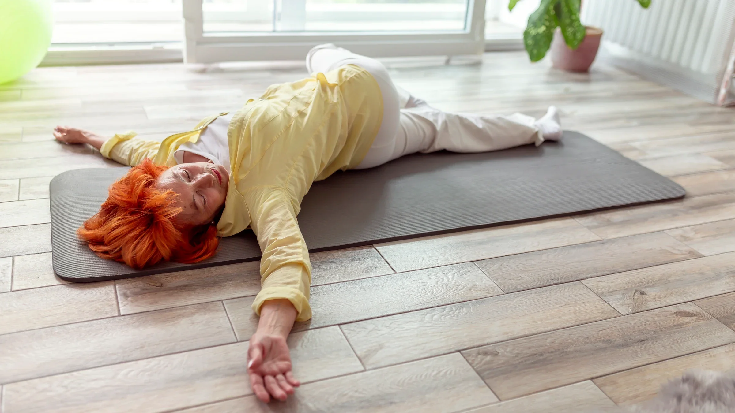 Woman doing a spinal-twist yoga exercise.
vladans/iStock via Getty Images Plus
