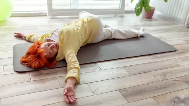 constipation: woman doing spinal twist yoga exercise 1216977604