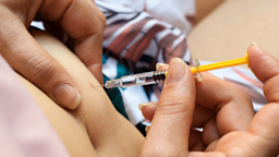A woman injects under the skin of her stomach with a needle to administer her medication.
Cristian Storto Fotografia/iStock via Getty Images Plus
