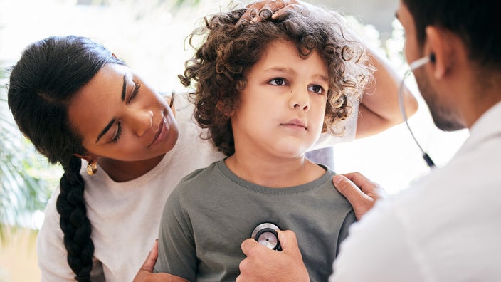 Doctor checking child's breathing with stethoscope