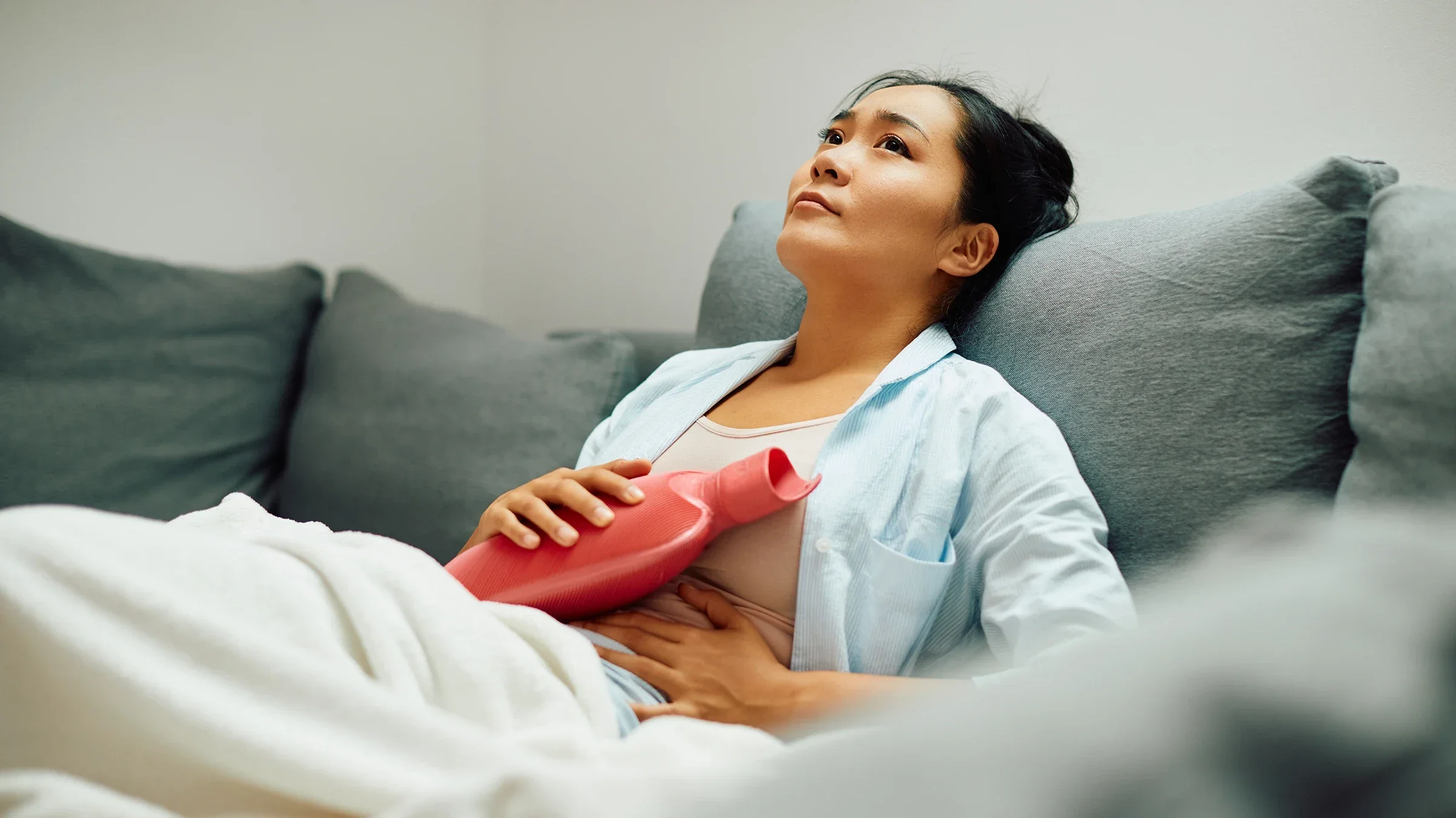 A woman holds a hot-water bottle on her stomach.
Drazen Zigic/iStock via Getty Images Plus