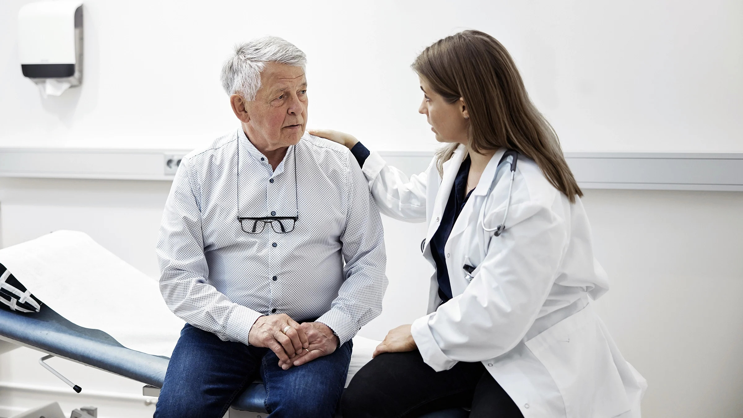 A man talks with his healthcare provider in an examination room. Prostate cancer can have different risk levels depending on the type of prostate cancer a person has. 