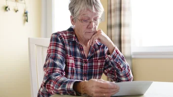 Personal Finance: woman reviewing paperwork 1080248188