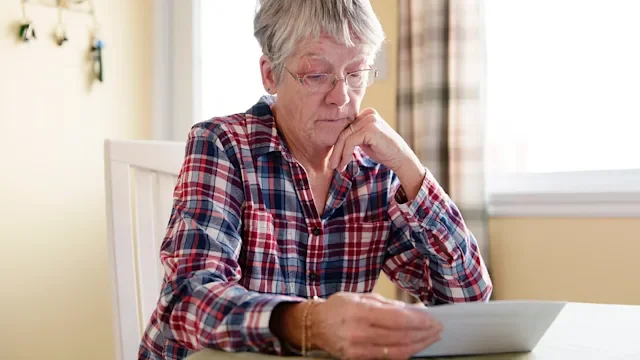 Personal Finance: woman reviewing paperwork 1080248188