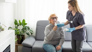 Medication Education: nurse helping woman at home with nebulizer 1485052638