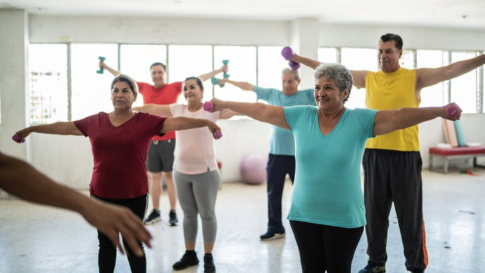 Older adults lift weights during a workout class.