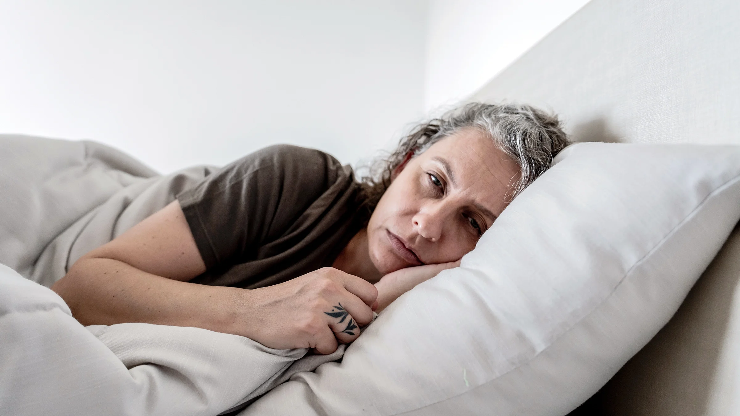 Tired woman lying in her bed