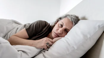 Sleep: tired woman lying in bed 1806182187