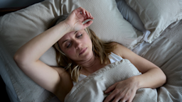 Menopausal woman, lying in bed, suffering from insomnia.
Highwaystarz-Photography/iStock via Getty Images Plus