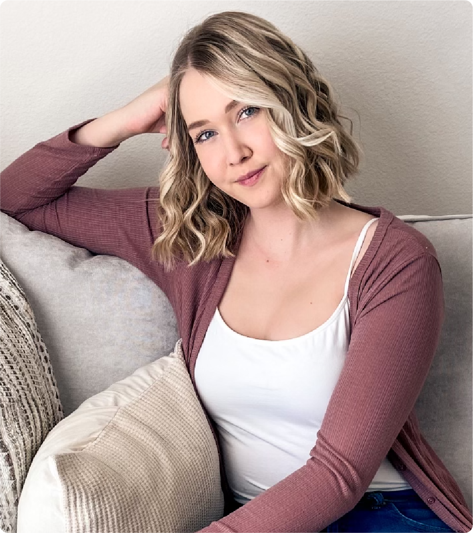 Samantha Boothe is pictured in a portrait at home, sitting on her couch.