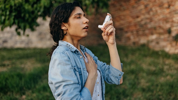 A person with allergies using an inhaler.