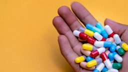 Handful of colorful capsule pills on a yellow background.
Fahroni/iStock via Getty Images
