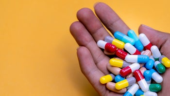 Aripiprazole: Interactions: hand full of pills yellow background 1340721540