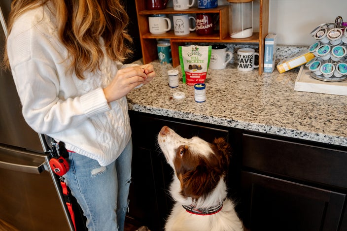 Beck Skaggs is giving a treat to her dog, Dak.