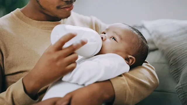 Health: Mens health: man feeding baby with bottle　1202450246